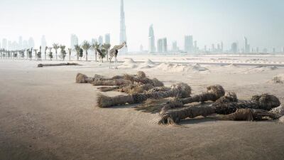 A giraffe wanders over desert with the Burj Khalifa in the background in Richard Allenby-Pratt's series Abandoned.