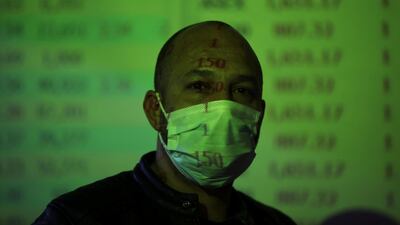A dealer walks past a trade screen at the Amman Stock Exchange after it was reopened in Amman, Jordan. Reuters