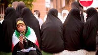 A woman uses a mobile phone in Tehran. The Iranian government pulled the rug from under Etisalat's planned expansion of operations into Iran.