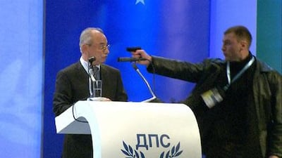 An image from a broadcast by the Bulgarian channel BTV shows a man pointing a gun at Ahmet Dogan, the leader of the MRF party of the Turkish minority in Bulgaria on Saturday. EPA / BTV / HANDOUT