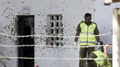 Sri Lankan police personnel investigate at the site of a blast in Wattala, a suburb of Colombo.