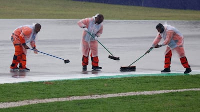 Marshals clear water from the track before the race. Reuters