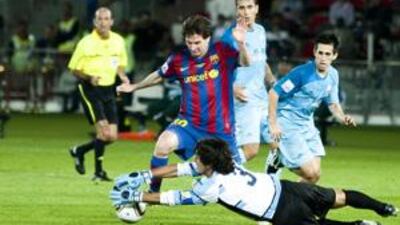 Atlante's goalkeeper, Federico Vilar, saves from Barcelona's Lionel Messi.