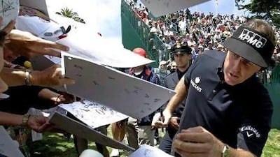 Phil Mickelson taks the time to sign autographs after his practice round for the US Open Championship. Mickelson will be paired with Tiger Woods and Masters winner Bubba Watson on Thursday and Friday.