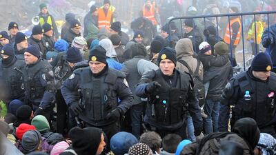 Croatian policemen contain refugees waiting to cross the Serbian-Croatian border near the village of Berkasovo. Elvis Barukcic / AFP Photo