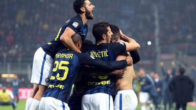 Ivan Perisic is mobbed by teammates after scoring a late equaliser for Inter Milan. Matteo Bazzi / EPA