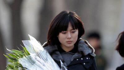 A woman holding flowers arrives at the North Korea embassy to mourn the death of North Korean leader Kim Jong-il in Beijing. REUTERS/Jason Lee