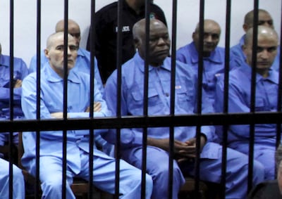 Abu Agila Mohammad Masud, second left, sits behind bars during a 2014 court hearing in Tripoli. Reuters