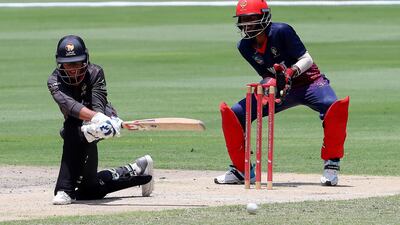 Niel Lobo looks to sweep the ball.