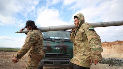 Syrian rebel fighters carry a Grad rocket in northwestern Syria. AFP