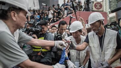 Journalists gather as workers assist bailiffs in removing tents under a court injunction in the Mong Kok district of Hong Kong. Hong Kong authorities tore down barricades at a protest site in Mong Kok, the scene of some of the more violent clashes to take place during nearly two months of pro-democracy sit-ins. Philippe Lopez / AFP