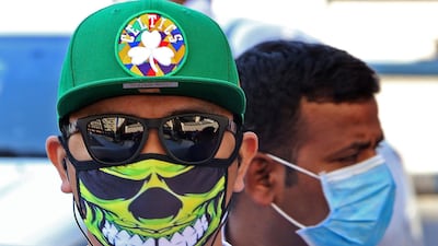 People wearing protective masks are seen on a street in Kuwait City, amid a global outbreak of the novel Coronavirus. AFP