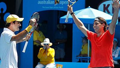 Roger Federer, left, and Rafael Nadal celebrate a point during a charity tennis event in Melbourne yesterday. The event is being held to raise money for the flood disaster that has caused 26 deaths in Australia.