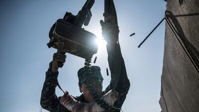 An Iraqi federal policeman fires a machine gun at an ISIS position on a nearby rooftop during fighting in west Mosul in April 2017. Getty Images