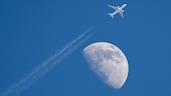 A civilian aircraft flying past the moon in Hsinchu, Taiwan. EPA