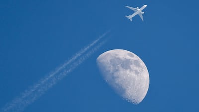 A civilian aircraft flying past the moon in Hsinchu, Taiwan. EPA