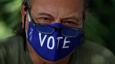 A poll worker waits for voters to arrive at a polling station in the Miami Beach Botanical Garden. AP