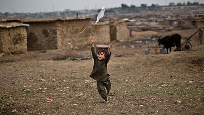 An Afghan refugee child chases a kite launched by his sister while playing in a field near their home on the outskirts of Islamabad, Pakistan. Muhammed Muheisen / AP Photo