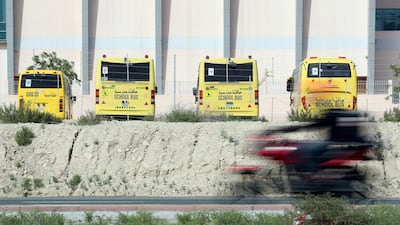 School busses parked up while a delivery scooter zooms passed on Hessa Street as Dubai goes into lockdown for 2 weeks due to the corona virus. Chris Whiteoak / The National