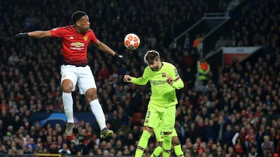 Manchester United's Anthony Martial, left, and Barcelona's Gerard Pique jump for the ball. AP Photo