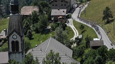 Cyclists ride through the village of Manigod during the 10th stage of the Tour de France between Annecy and Le Grand-Bornand. Jeff Pachoud / AFP