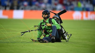 The Greenpeace activist sits on the pitch after landing. EPA
