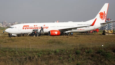 Officials check an aircraft belonging to Malindo Airlines that skidded off the runway during take off on the night of April 19, 2018 at Tribhuvan International Airport in Kathmandu, Nepal. Navesh Chitrakar / Reuters