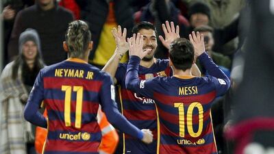 Luis Suarez, centre, celebrates with teammates Leo Messi, right, and Neymar. Quique Garcia / EPA