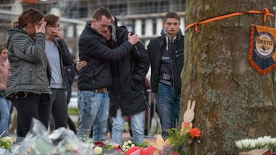 People cry after laying flowers at a makeshift memorial site for the victims of a shooting incident in a tram in Utrecht, Netherlands. AP