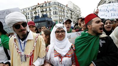 Students wearing traditional clothes hold banners and shout slogans during a protest calling on President Abdelaziz Bouteflika to quit, in Algiers, Algeria March 26, 2019. Reuters