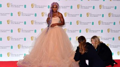 Actress Cynthia Erivo has her dress rearranged as she poses in the winners' room as a citation reader at the British Academy Film Awards 2019. AFP