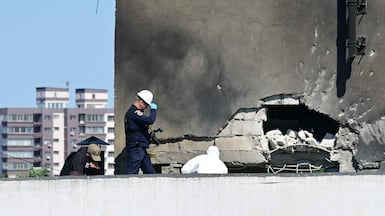 Romanian emergency personnel assess the damage to the residential building struck by a Russian drone. AFP