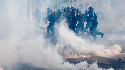 French gendarmes run through smoke of tear gas, during a May Day demonstration when more than 7,400 police and gendarmes were deployed across Paris. AFP