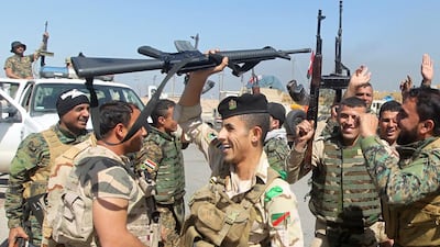 Iraqi soldiers cheer on the outskirts of Tikrit, as they prepare to launch a military operation to take control of the city from ISIL on March 10, 2015. A new fund set up by the UAE and Germany could help to restore basic infrastructure, services and governance to liberated parts of Iraq, such as Tikrit. Ahmad Al Rubaye/AFP Photo