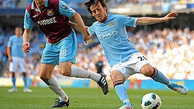 David Silva, right, the Manchester City winger, fends off the challenge of West Ham's Jonathan Spector yesterday.