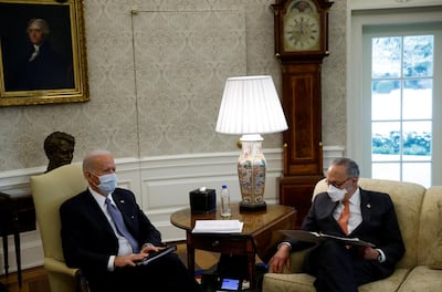 US President Joe Biden sits next to Senate Majority Leader Chuck Schumer as he meets Democratic senators in the Oval Office at the White House on February 3, 2021. Reuters