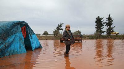 A Syrian boy, stands in a water logged field outside a tent in the Cordoba camp for internally displaced Persons (IDP), close to Batabu town, along the highway leading to the Syrian Bab al-Hawa border crossing with Turkey, in the northern Syrian Idlib province. Following heavy rain storms, the camp has become water logged, flooding the tents and making the the roads muddy and difficult to maneuvre on. AFP