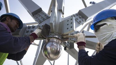 Labourers finish last details as they work on an installation of a super-sized element weighing about 41 tons. Silvia Razgova / The National