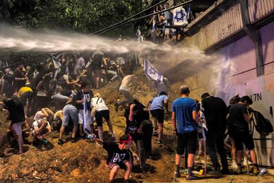 Israeli police use water cannon to disperse demonstrators protesting against the government's judicial overhaul plan in Tel Aviv on Saturday. AFP