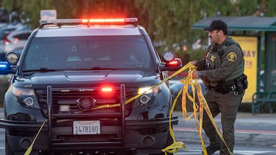A police officer removes yellow tape from the crime scene. AP