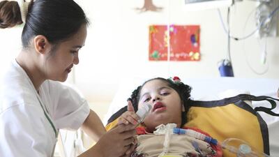 Sara Al Shamsi with Janice, a nurse at the Amana Healthcare facility in Al Ain. Since moving to the facility five months ago, Sara and her sister Noor, who have muscular dystrophy, have made remarkable progress. Lee Hoagland/The National
