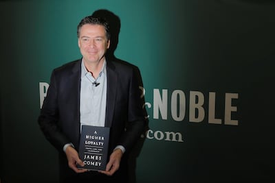 Former FBI director James Comey poses with his book, 'A Higher Loyalty', in New York on April 18, 2018. Lucas Jackson / Reuters