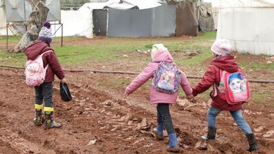 Internally displaced Syrian children walk near tents at a camp in northern Aleppo near the Syrian-Turkish border, February 17, 2021. REUTERS