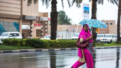 Many residents have got used to carrying an umbrella, such as this Dubai shopper, as the downpours continue. Victor Besa for The National