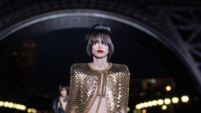 Gleaming gold mesh is carved into a box-shouldered cape at Saint Laurent.