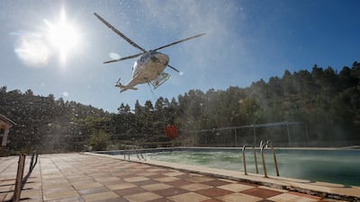 A helicopter collects water as part of efforts to extinguish a wildfire near Fuente la Reina, in Castellon, Spain. EPA
