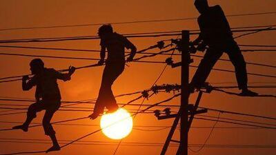 Linemen repair high tension wires on the banks of the Ganges River in Allahabad. Many Indians in rural areas have no access to electricity. Rajesh Kumar Singh / AP Photo