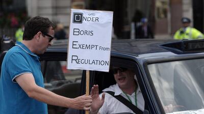 A demonstrator holds a placard during a protest by London black cab drivers against Uber, a mobile phone app. Carl Court / AFP
