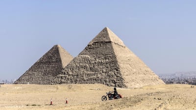 People ride their motorcycles during an organised tour at the Giza Pyramids in Cairo, Egypt. AFP