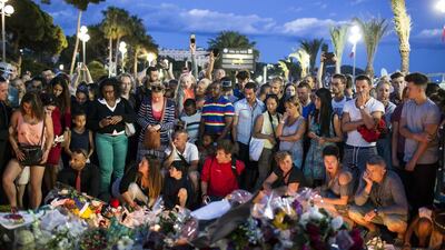 People gather on July 15, 2016 at a makeshift memorial to honor the victims of the attack in Nice on Bastille Day. Laurent Cipriani/ AP